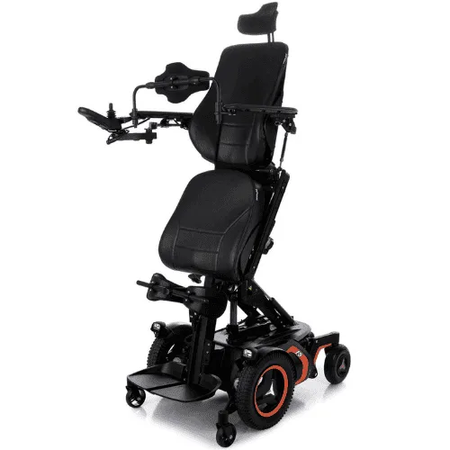 Permobil F5 Corpus akülü sandalye, ayakta konumda, turuncu jant detayları, önden çapraz açıdan